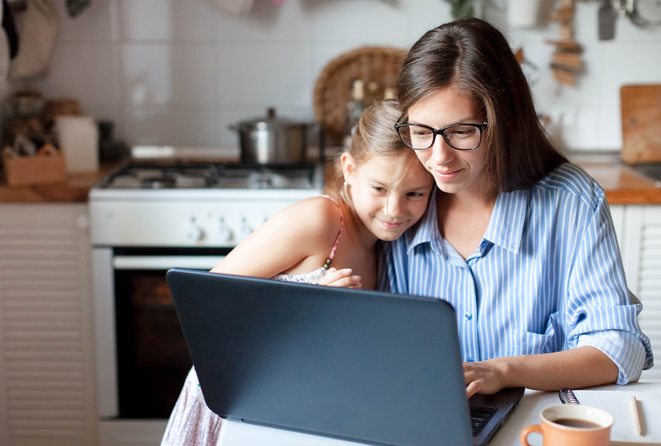 Mutter und Tochter suchen am Laptop nach Ergotherapeuten