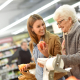 Frau hilft Seniorin beim einkaufen