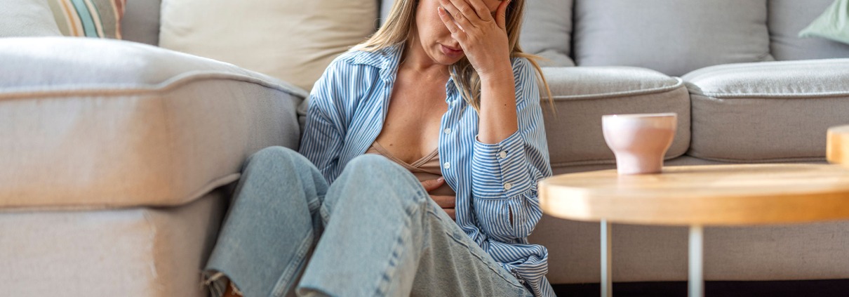 Junge Frau sitzt auf dem Boden im Wohnzimmer