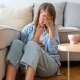 Junge Frau sitzt auf dem Boden im Wohnzimmer